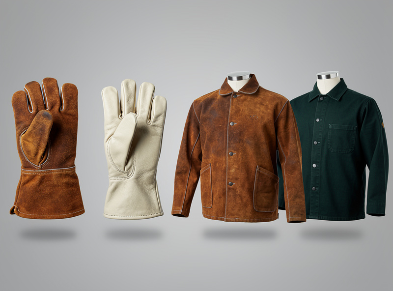 Photograph of two pairs of welding gloves on a workbench: heavy cowhide MIG/stick gauntlets with 6-inch cuffs on the left, and thin goatskin TIG gloves with short cuffs on the right