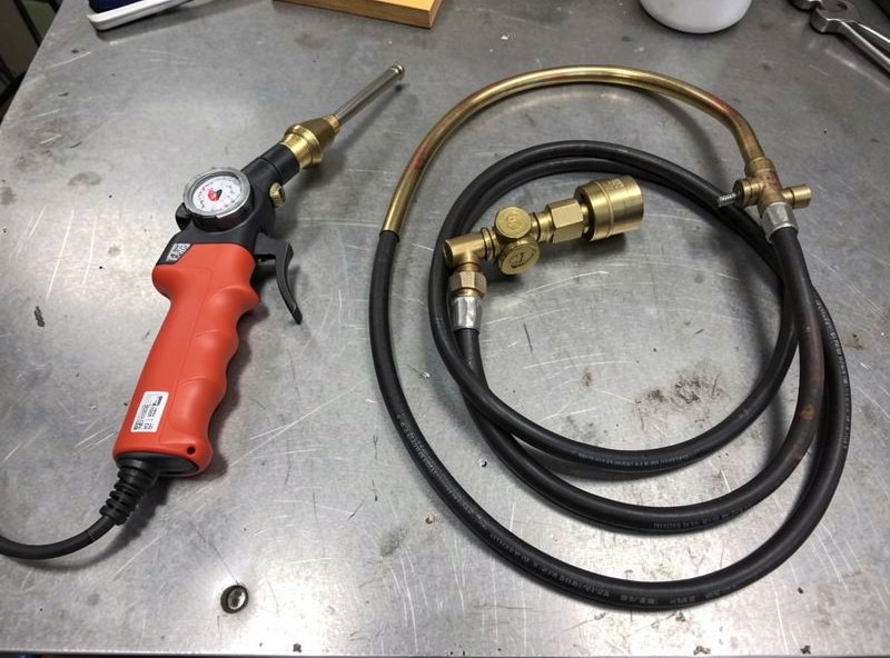A MAP-Pro hand torch next to a full oxy-acetylene torch with regulators and hoses on a workbench