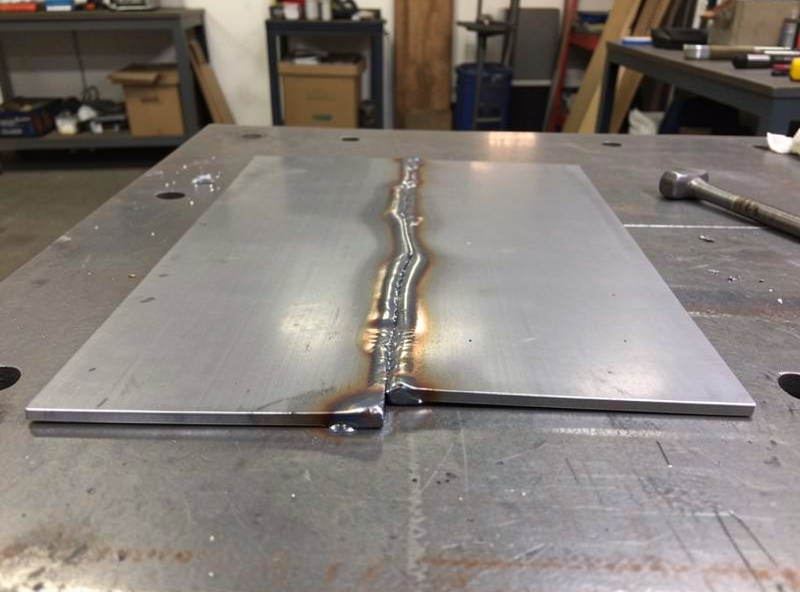 Two thin steel plates warped and bowed upward along a weld seam from welding heat