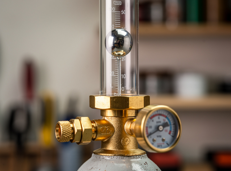 Floating-ball MIG flowmeter regulator mounted on an argon CO2 cylinder set to 22 CFH in a home workshop