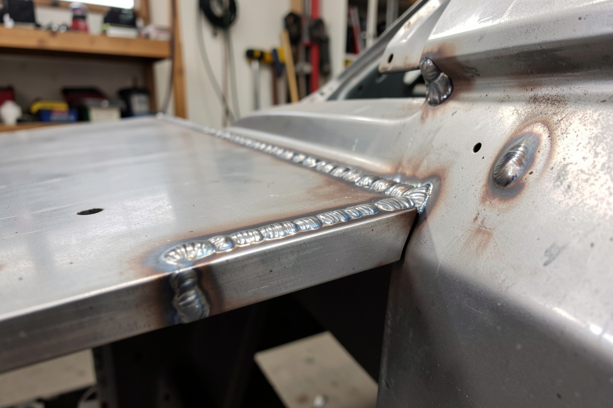 Row of plug welds along an overlapping car panel flange copying factory spot welds