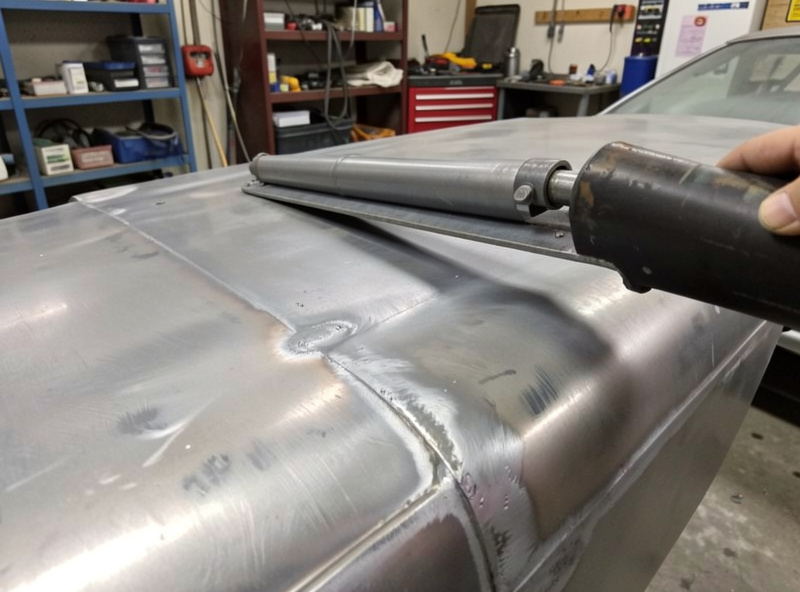 A heat-shrunk auto panel checked flat with a body file before a thin skim of filler