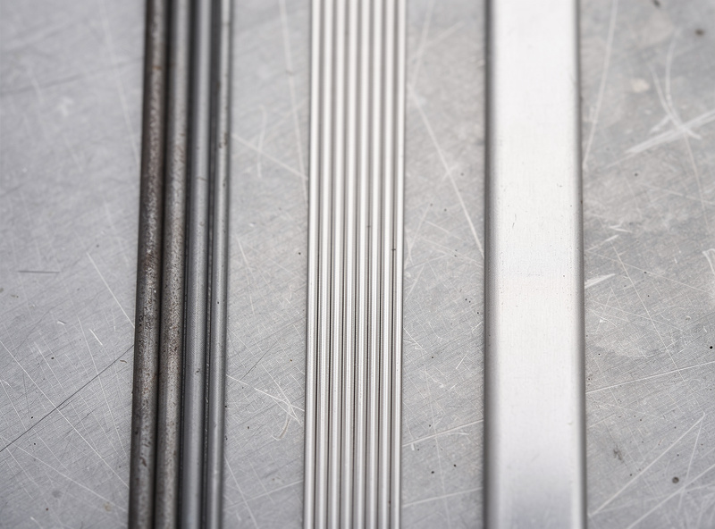 Comparison of steel, stainless, and aluminum TIG filler rods laid out side by side on a clean bench