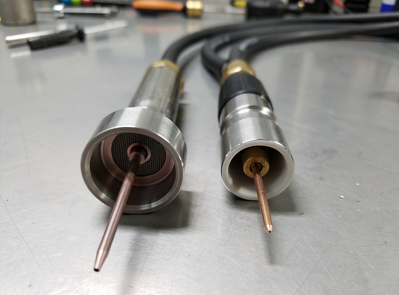 Comparison of two TIG torch setups, one with a gas lens and long stickout for walking the cup and one with short stickout for freehand