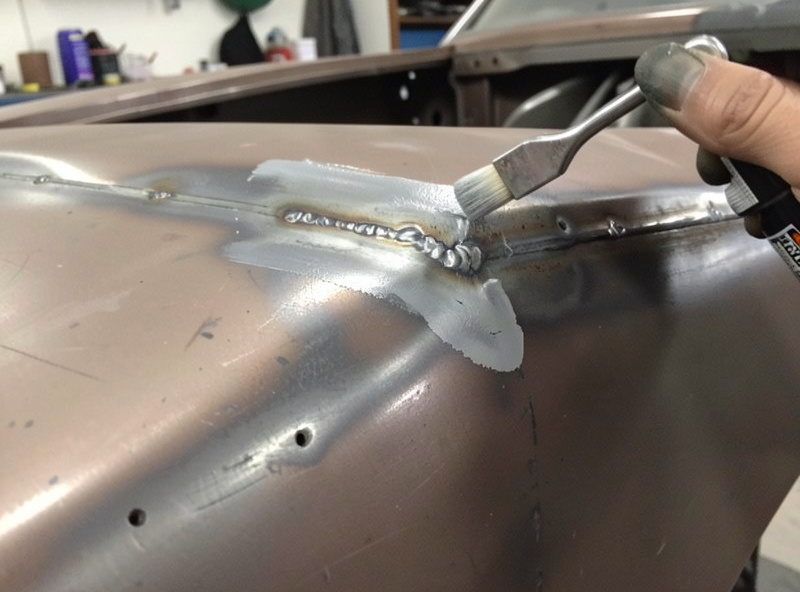 Sealing and priming a finished weld repair on a car body panel to prevent rust
