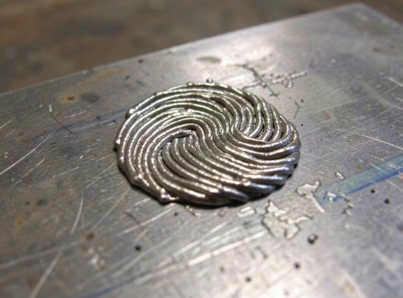Finished flux-core weld bead with slag chipped away showing stacked ripples on a steel plate