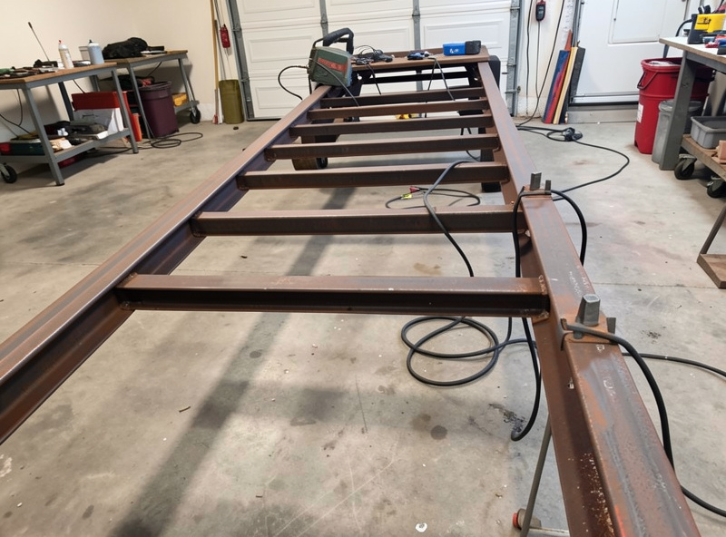 Steel crossmembers tacked evenly spaced between two main rails of a utility trailer frame