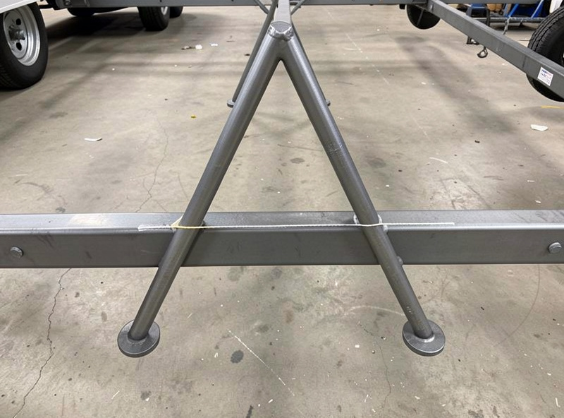 Two steel tongue legs forming a triangular A-frame clamped to the front of a trailer frame and checked for centerline