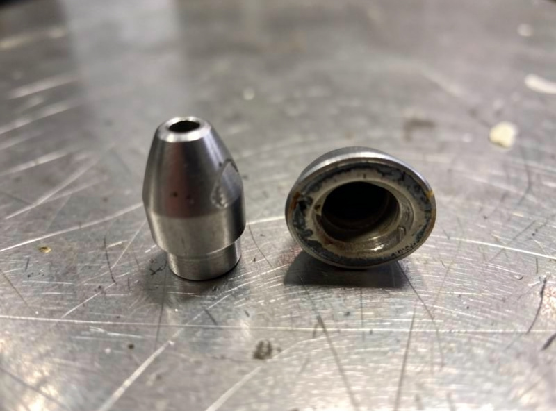 Macro comparison of a new contact tip next to a worn contact tip with an enlarged oval bore
