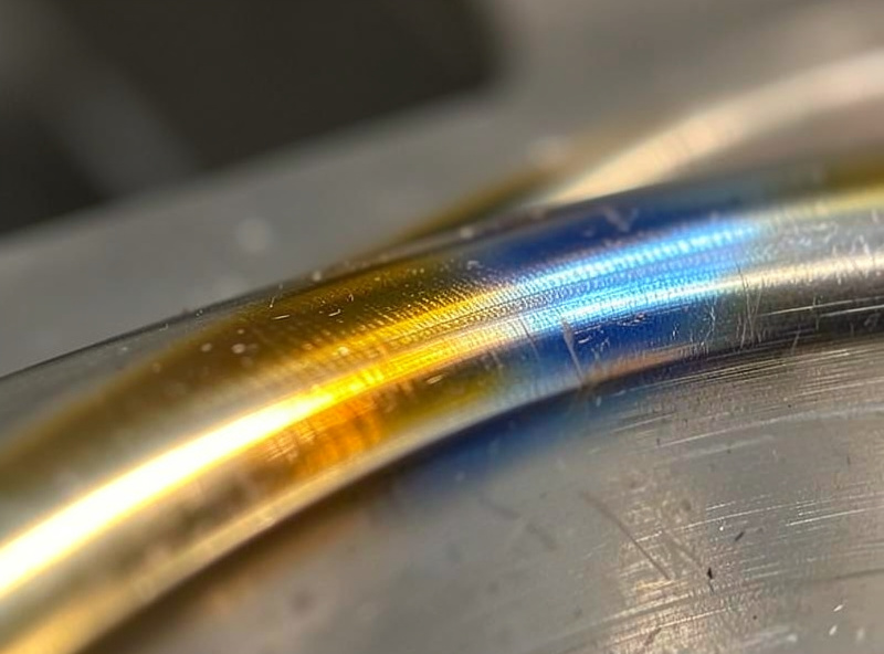 Straw and blue temper colors on a stainless steel TIG weld bead